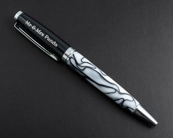 May include: A ballpoint pen featuring a black cap engraved with the text Mr & Mrs Panda, a silver clip, and a white barrel with a black marbled pattern. The pen has a polished silver tip and silver accents separating the cap from the barrel.