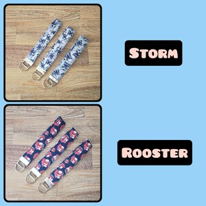 May include: Three keychains with different designs. The first keychain has a blue and white pattern with the word "STORM" printed on it. The second keychain has a red and blue pattern with the word "ROOSTER" printed on it.