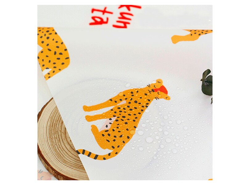 May include: White fabric with a repeating pattern of orange and black leopards. The fabric is wet with water droplets. The text "Fun at the" is visible in red.