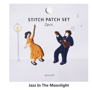 Può includere: Un set di due toppe ricamate da stirare che raffigurano una donna con un vestito giallo e un uomo che suona la chitarra. Le toppe sono intitolate "Jazz In The Moonlight" e "Stitch Patch Set 2pcs."