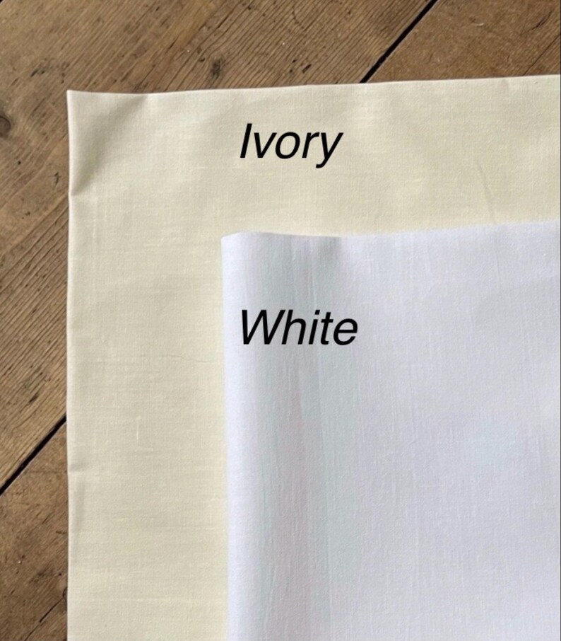 May include: Two fabric swatches, one ivory and one white, with the color names written below each swatch.