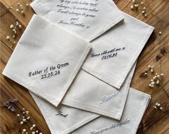 May include: A collection of five white fabric handkerchiefs featuring various embroidered messages in black and blue thread, including "Dad Thank you for walking by my side today and always," "Father of the Groom 25.05.24," "Grow old with me 03.05.24," "Brooke," "Jack," and "Keep your shit together."