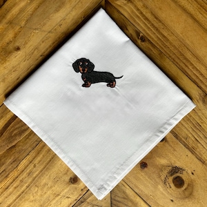 Peut inclure: Serviette de cuisine blanche avec un teckel noir et brun brodé.
