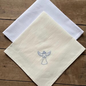 May include: Two white linen tea towels, one with a blue embroidered angel design.