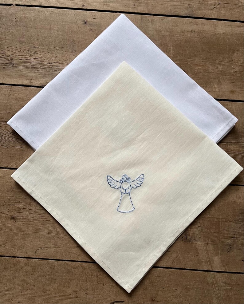 May include: Two white linen tea towels, one with a blue embroidered angel design.