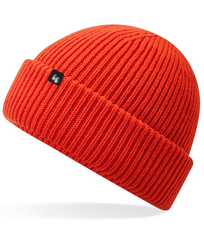Recycled polyester beanie in fire red with a small black fabric tag on the front left-hand side