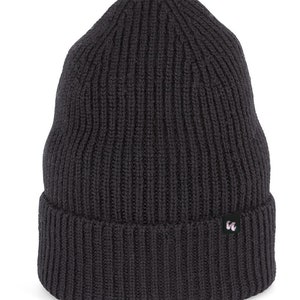 A black beanie with chunky, fisherman-style ribbed knit. It has a black fabric label with a white logo stitched to the cuff