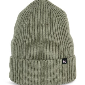 An olive green beanie with chunky, fisherman-style ribbed knit. It has a black fabric label with a white logo stitched to the cuff