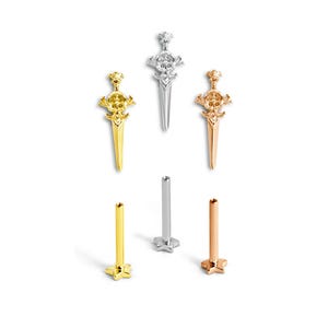 Op de afbeelding: Een assortiment oorbellen in goud, zilver en roségoud. De afbeelding toont drie dolkvormige oorbellen met een schedelontwerp en drie oorstekers met een stervormige basis.