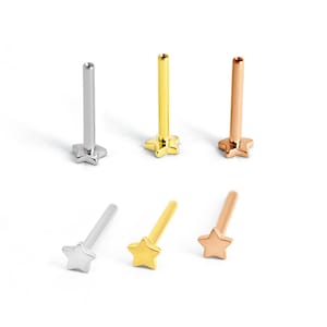 May include: A collection of star-shaped stud earrings in silver, gold, and rose gold. The earrings have a straight post and a star-shaped base. The earrings are displayed on a white background.