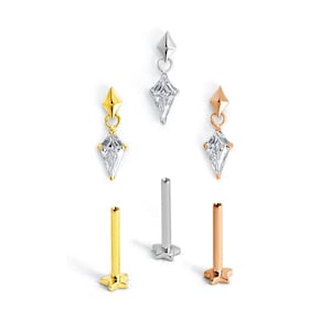 Könnte beinhalten: Drei baumelnde Anhänger in Drachenform mit klaren facettierten Steinen in Silber-, Gold- und Roségoldtönen, gepaart mit drei passenden Labret-Steckern mit flacher Rückseite in entsprechenden Metalloberflächen, vertikal angeordnet.