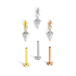 May include: A collection of three stud earrings and three dangling earrings. The earrings feature a diamond-shaped, clear gemstone and are available in gold, silver, and rose gold finishes. The studs have a star-shaped base.