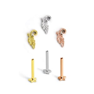 Op de afbeelding: Drie decoratieve metalen bladvormige opzetstukken en drie bijbehorende metalen staafjes. De bladstukken zijn afgewerkt in zilver-, goud- en roségoudtinten. De staafjes hebben een stervormige basis en zijn ook in zilver, goud en roségoud uitgevoerd.