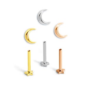 Op de afbeelding: Een collectie lichaamsjuwelen met halve maan- en sterontwerpen. De sieraden omvatten drie halve maan studs in zilver, goud en roségoud. Er zijn ook drie stervormige studs in goud, zilver en roségoud.