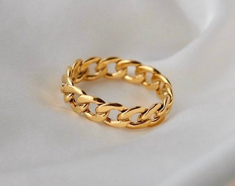 May include: A gold chain ring with a thick, chunky design. The ring is made of metal and has a polished finish.