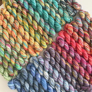 May include: A collection of colorful yarn skeins in various hues, including yellow, orange, green, blue, and purple. The yarn is arranged in a radial pattern, showcasing the vibrant color variations. Ideal for knitting or crochet projects.