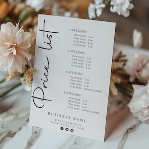 Könnte beinhalten: Eine weiße Preislistenkarte mit den Worten "Price List" in eleganter Schrift. Die Karte listet Kategorien und Artikeldetails auf. Die Karte ist von zarten rosa und weißen Blumen und Blättern umgeben.