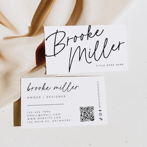 May include: Two white business cards with black text. The top card has the name "Brooke Miller" in cursive, with "TITLE GOES HERE" below. The bottom card has the name "Brooke Miller", "OWNER / DESIGNER", contact info, and a QR code.