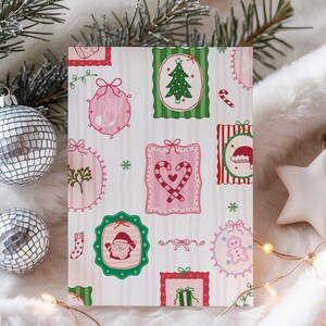 Könnte beinhalten: Eine rechteckige Weihnachtskarte mit verschiedenen festlichen Illustrationen in Rosa, Grün und Rot. Die Karte ist mit Bildern eines Weihnachtsbaums, des Weihnachtsmanns, Zuckerstangen und Lebkuchenmännern verziert. Der Hintergrund ist eine weiche, weiße, flauschige Textur mit silbernen Discokugel-Ornamenten und einem Stern.