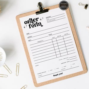 Puede incluir: Un portapapeles con un "Formulario de pedido" impreso en papel blanco, con una fuente negra y estrellas decorativas. El portapapeles es de madera marrón claro y tiene un clip metálico. También se ven clips dorados y una madeja de hilo.