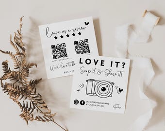 May include: Two square white cards with black text and graphics. One card features the text Leave us a review, five stars, and two QR codes. The other card displays the text LOVE IT? Snap it & Share it! with a camera icon and social media icons.