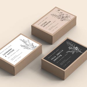 Puede incluir: Tres cajas rectangulares de jabón con etiquetas. Las cajas son marrones con etiquetas blancas o negras. Las etiquetas tienen ilustraciones botánicas y texto: "lavanda y algodón", "infusión de cítricos" y "esto huele increíble". Cada caja es de 113g.