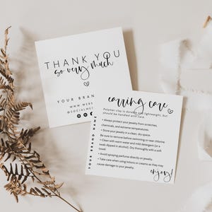 May include: Two white cards with black text, one reading "THANK YOU so very much" and the other "caring care". A dried fern and white ribbon are also present. The cards provide brand information and care instructions.