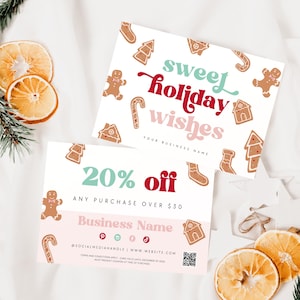 May include: Two holiday-themed cards with the text "sweet holiday wishes" and "20% off." The cards feature gingerbread men, houses, and other festive designs. Dried orange slices and pine branches add a seasonal touch.