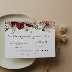 May include: A rectangular white thank you card featuring a floral illustration in shades of red, pink, and green at the top. The text reads thank you for your order, I hope you love it as much as I loved creating it, enjoy 10% off your next order with code THANKYOU10, @socialmediahandle, website.com, love what you got? leave us a review, and business name here.
