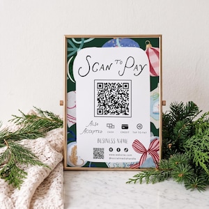 May include: A gold-framed sign with a dark green background featuring holiday ornaments. The center white panel reads Scan to Pay above a QR code, followed by Also Accepted with icons for cash, credit, and tap to pay, plus a business name area.