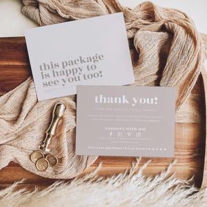 May include: Two rectangular cards with white and light brown backgrounds. One card features the text "this package is happy to see you too!" and the other says "thank you!" with social media icons. A gold metal wax seal stamp is included.