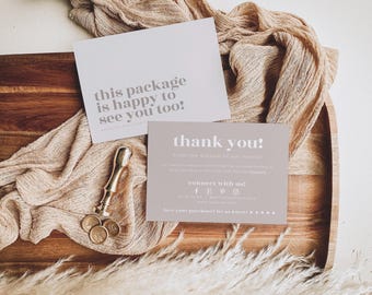 May include: Two rectangular cards with white and light brown backgrounds. One card features the text "this package is happy to see you too!" and the other says "thank you!" with social media icons. A gold metal wax seal stamp is included.