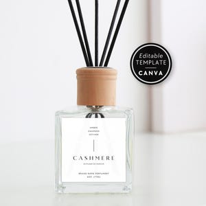 Könnte beinhalten: Ein quadratischer Glas-Diffusor mit hellem Holzdeckel und schwarzen Stäbchen. Das weiße Etikett trägt den Text Amber, Oakmoss, Vetiver, Cashmere, Diffuseur de Parfum, Brand Name Perfumery und 4oz (113g). Ein schwarzes, kreisförmiges Abzeichen zeigt den Text Editable Template Canva.