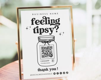 Puede incluir: Un letrero rectangular vertical en un marco de metal dorado fino con el texto negro "BUSINESS NAME", "feeling tipsy?", "thank you !" y "@SOCIALMEDIAHANDLE". Un gráfico central muestra un frasco con un código QR, el logo de CashApp e iconos.
