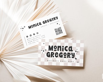 May include: Two rectangular business cards featuring the name Monica Gregory in a bold, rounded black font. One card is white with contact details and a QR code, while the other has a beige and white checkered pattern with star accents.