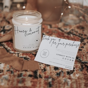 May include: A white candle jar with a black label that reads "Honey & Coconut" and "Soy Wax Candle" with a heart icon. The candle is on a patterned rug with a thank you card that reads "Thank you for your purchase" and includes a logo placeholder, social media icons, and the text "Connect with us".