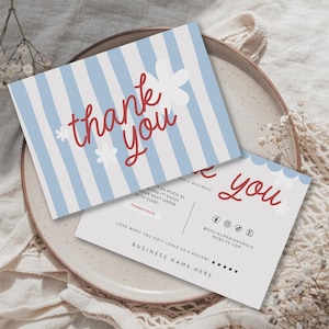 May include: Two rectangular thank you cards featuring a light blue and white vertical striped pattern with white flower accents and red cursive text. The second card includes social media icons, a discount code, and a five-star review prompt.
