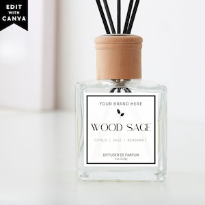 Könnte beinhalten: Ein durchsichtiger Glas-Diffusor mit hellem Holzdeckel und schwarzen Stäbchen. Das quadratische Etikett trägt den Text: YOUR BRAND HERE, WOOD SAGE, CITRUS | SAGE | BERGAMOT, DIFFUSER DE PARFUM, 4 oz. (113g). Ein schwarzes Etikett zeigt den Text EDIT WITH CANVA.