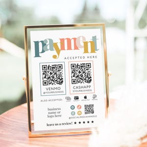 以下が含まれることがあります： カラフルな文字で「payment」と書かれた額入りのサイン。VenmoとCash AppのQRコード、および利用可能な支払い方法が表示されています。サインにはソーシャルメディアハンドルとレビューを求めるリクエストも含まれています。