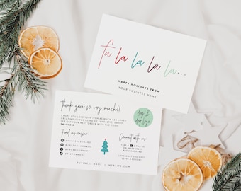 May include: Two white rectangular business cards with holiday-themed text. One card features the text fa la la la... and Happy Holidays From Your Business Name. The other card includes Thank you so very much!!, social media icons, and a small tree graphic.