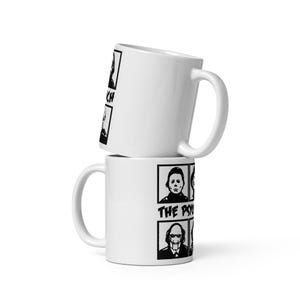 May include: Two white ceramic mugs stacked vertically, each featuring a black graphic print. The design includes four square panels with illustrations of horror movie characters and the text THE PSYCHO in bold black lettering on the side.