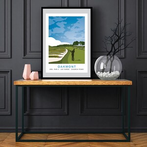 May include: A black framed poster with a colorful illustration of a golfer on a green golf course. The poster has the text "Oakmont" and "3rd. Par 4 - 426 Yards - 'Church Pews'".