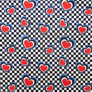 May include: A white and blue checkered fabric with red hearts. The hearts have a blue outline and a white inner ring.