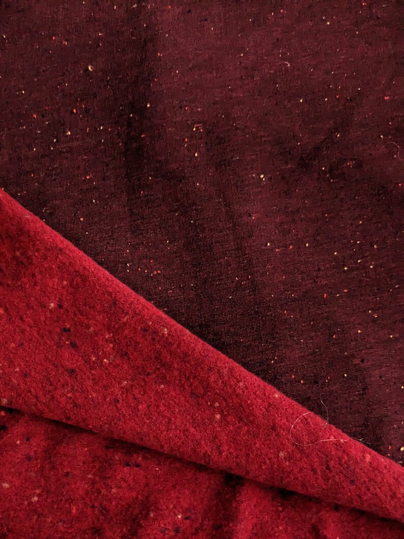K&ouml;nnte beinhalten: Zwei Stoffst&uuml;cke, eines in Dunkelburgunder mit einer gesprenkelten Textur und das andere in Dunkelrot mit einer &auml;hnlichen gesprenkelten Textur. Der burgunderfarbene Stoff ist &uuml;ber den roten Stoff gelegt.