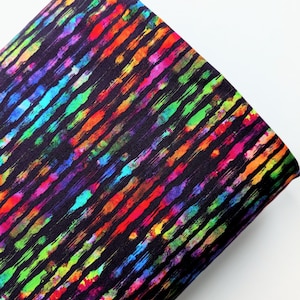 Pode incluir: Tecido preto com um padrão de listras verticais coloridas. As listras são compostas por uma variedade de cores, incluindo vermelho, laranja, amarelo, verde, azul e roxo. O tecido tem uma superfície ligeiramente texturizada.