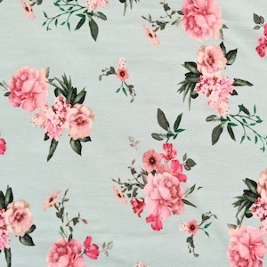 May include: A light blue fabric with a repeating floral pattern. The design features clusters of pink and red flowers with green leaves. The flowers vary in size and style, creating a textured and visually appealing pattern.