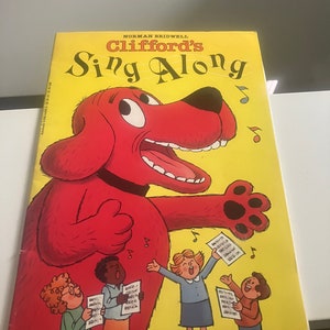 May include: A red dog with a large mouth, called Clifford, is singing with four children. The book cover is yellow with the title "Clifford's Sing Along" in black and white text.