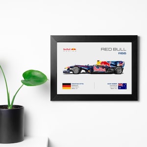 May include: A framed print of a Red Bull Racing Formula One car, the RB6, with the drivers Sebastian Vettel and Mark Webber. The car is blue and black with red accents. The print includes the drivers' names, nationalities, and race results.