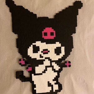 May include: A pixelated character in black, white, and pink. The character has large, pointed ears, a pink skull on its forehead, and small pink accents on its arms and tail. The character is standing.