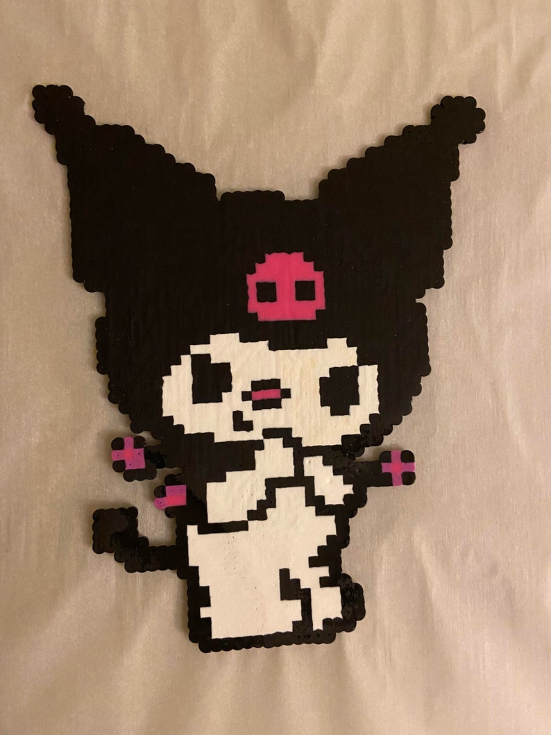 May include: A pixelated character in black, white, and pink. The character has large, pointed ears, a pink skull on its forehead, and small pink accents on its arms and tail. The character is standing.